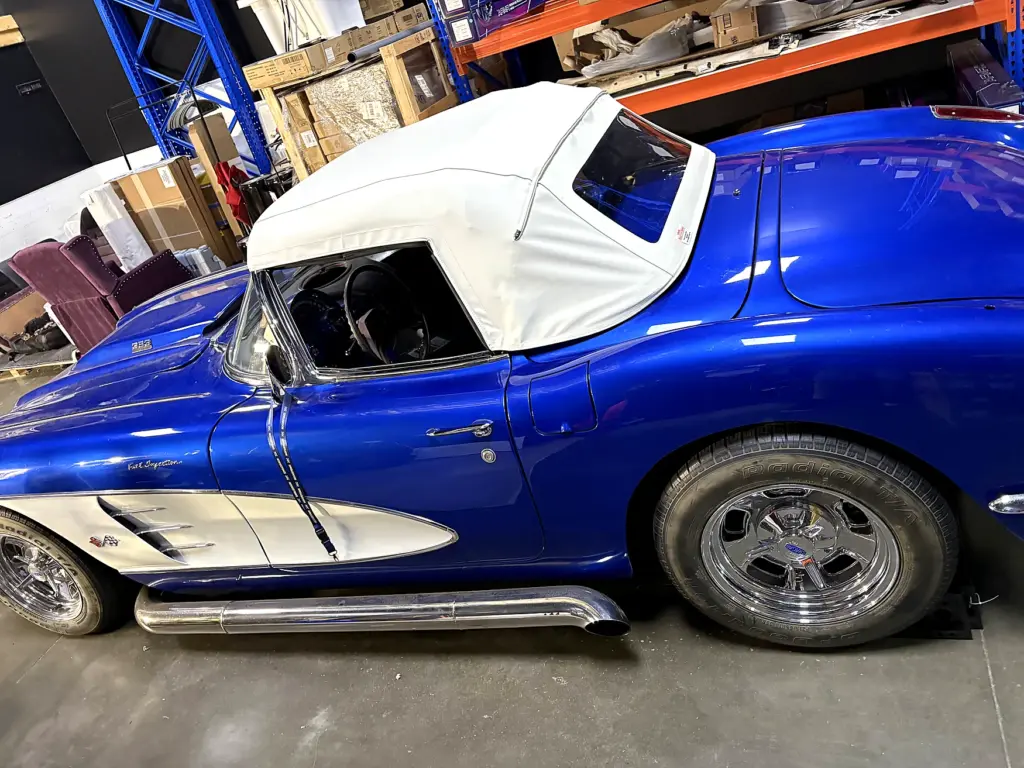 Classic Cobra roadster with a white convertible soft top