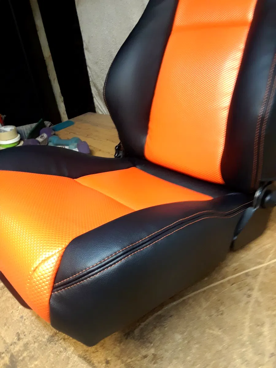 Black and orange custom upholstered seat with stitched bolsters and orange center panels