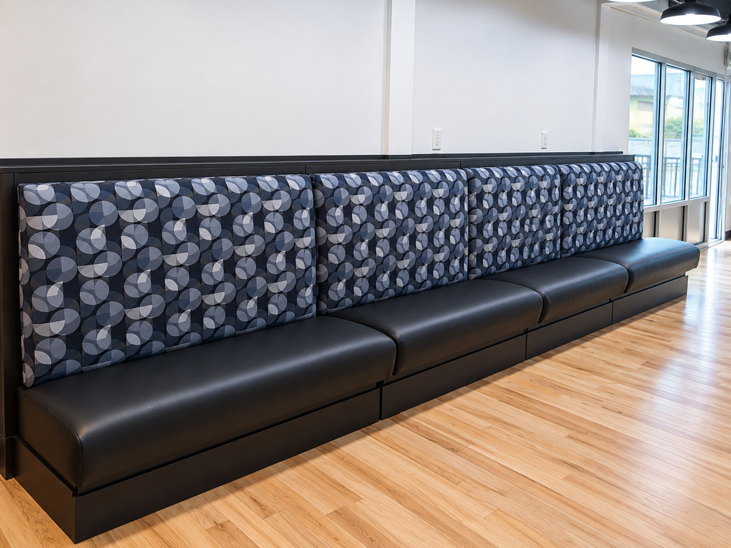 Illustrative commercial banquette seating with geometric-patterned backrests and dark upholstered cushions