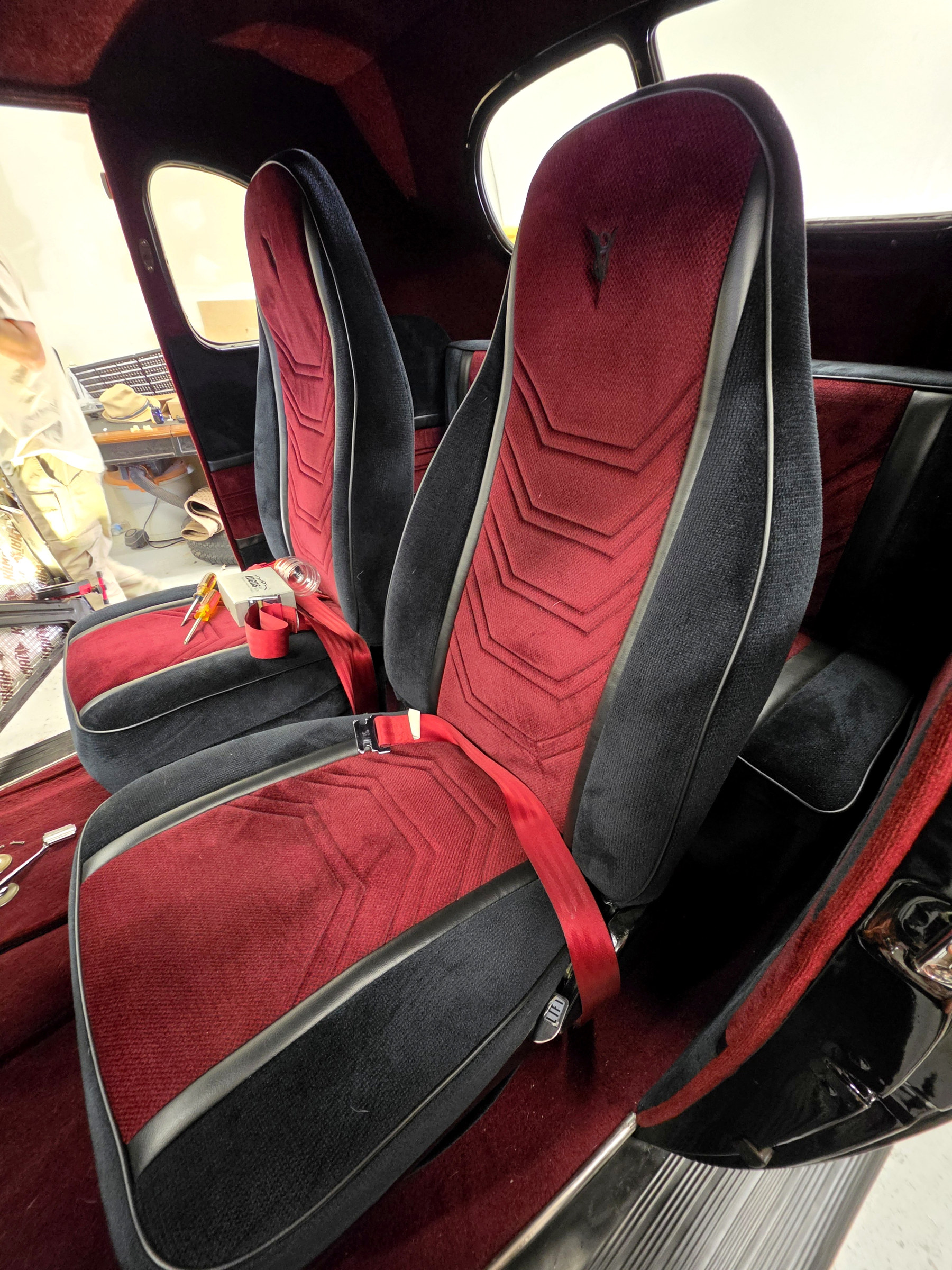 Custom red and black upholstered front seats in a classic car at Fine Line Auto Trim and Upholstery