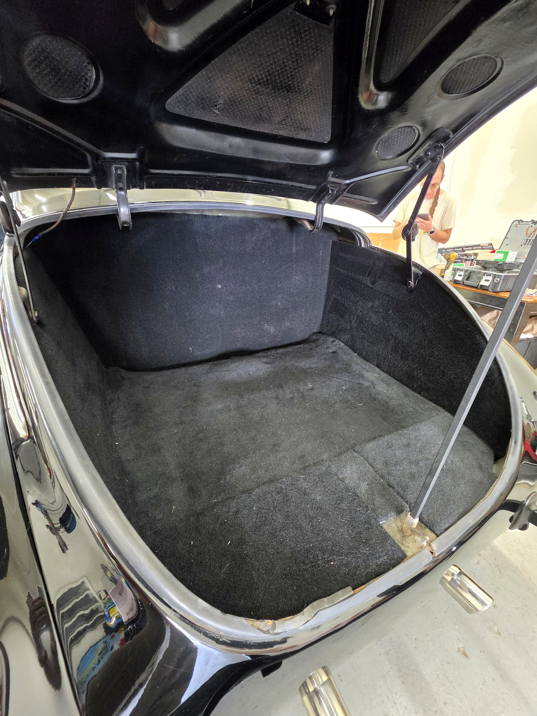 Alternate view of classic car trunk with restored dark carpeting and custom upholstered liner
